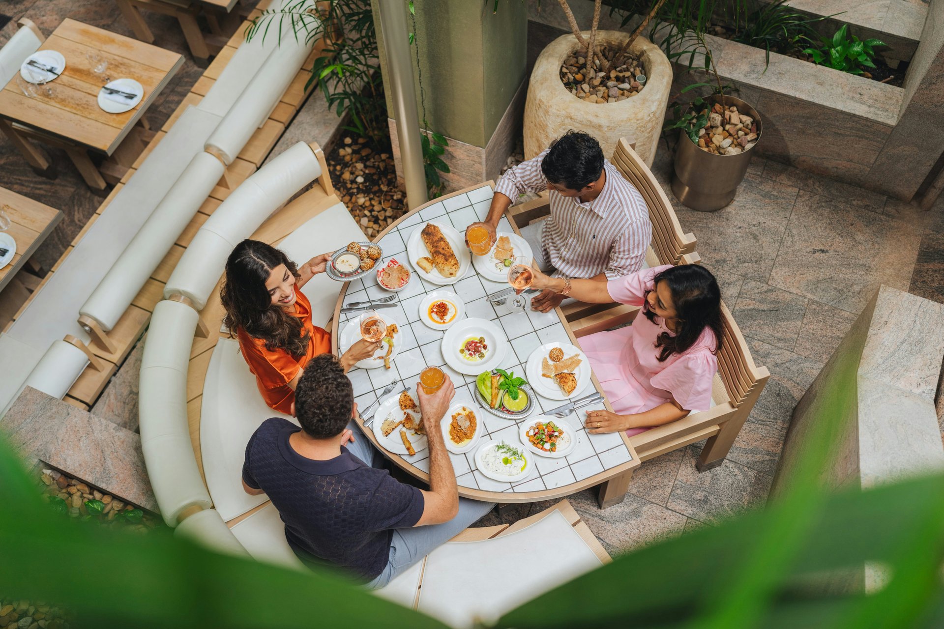 Friends sharing a meal at a leafy restaurant