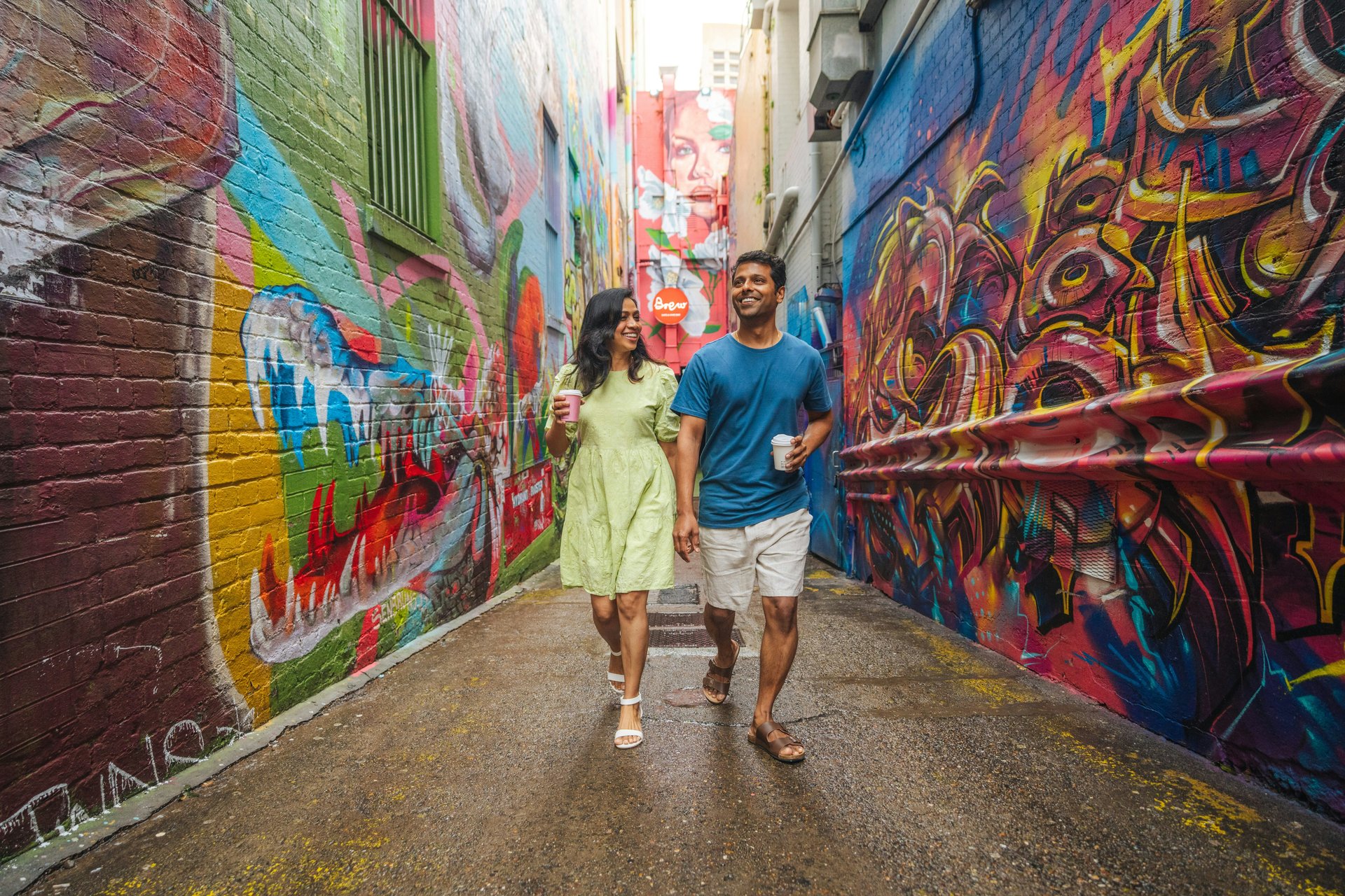 Travellers walking through a colourful street-art laneway